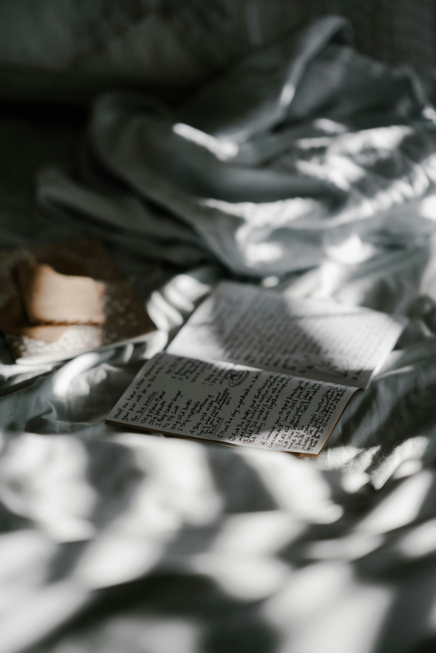 shallow focus photography of booklet on top of white textile